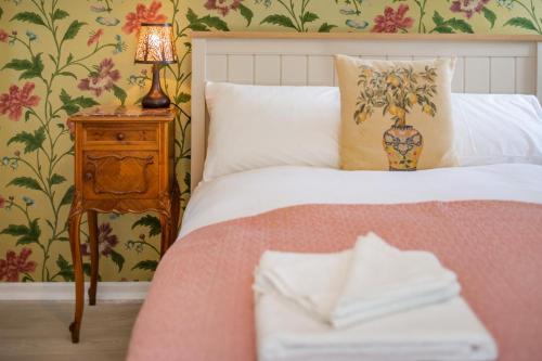 une chambre avec un lit et une table avec une lampe dans l'établissement Rose Cottage - Stoke Abbott, à Stoke Abbott
