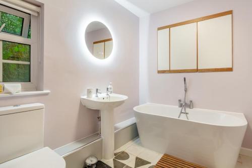 une salle de bain blanche avec un lavabo, une baignoire et des toilettes dans l'établissement Rose Cottage - Stoke Abbott, à Stoke Abbott