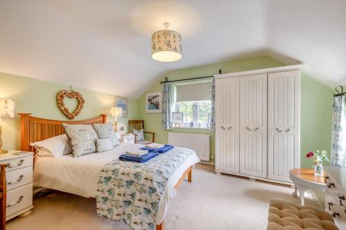 a bedroom with a bed and a large window at Olive Tree Cottage in Portesham