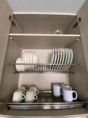 a refrigerator filled with white cups and plates at Acogedor y cómodo apartamento in Sabaneta