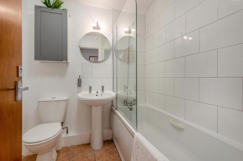 a bathroom with a toilet and a sink and a shower at Nellys in Swanage