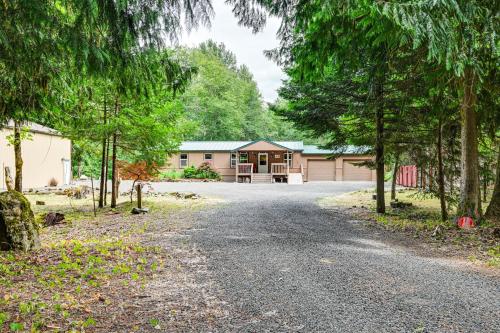 a driveway leading to a building with a garage at Gateway to Mt Rainier Riverfront Haven with Hot Tub in Packwood