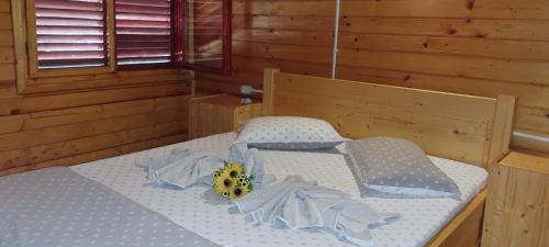 a bedroom with a bed with a flower on it at Pensiunea La Tavi in Murighiol