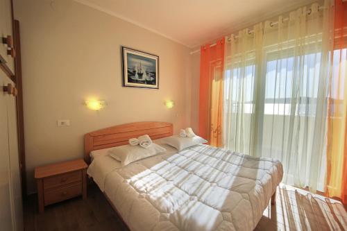 a bedroom with a bed and a large window at Apartments Šuperba in Brodarica