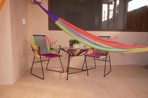 a hammock in a room with two chairs and a table at Disfruta en La Casa de Lola / Enjoy at Lolas house in Progreso