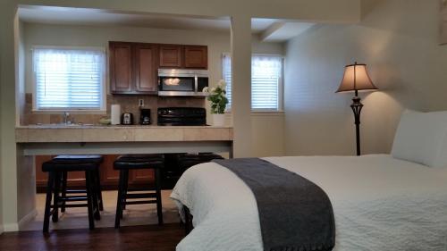 a bedroom with a bed and a kitchen at Trees Motel in Bishop