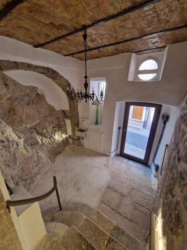 a large room with a stone wall and a chandelier at Residenza L'Antico Orologio in Alfedena