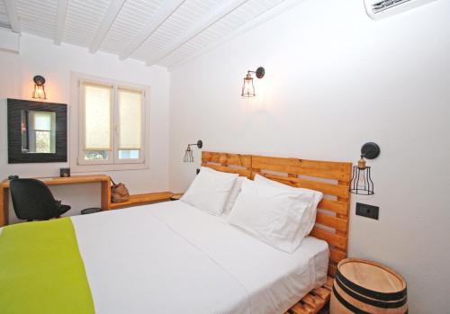 a bedroom with a bed and a desk and a chair at Camara Studio Mykonos in Ornos