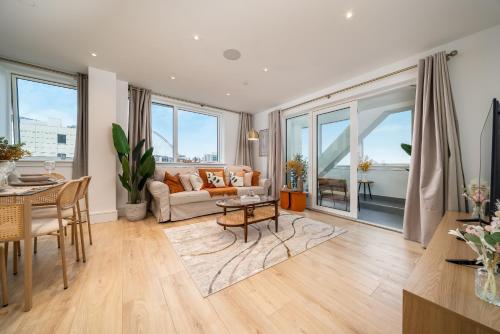 a living room with a couch and a table at Modern Apartment in Wembley Park with Cinema, Gym & Games room in London
