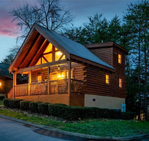 a log cabin with a porch and a large window at Escape to the Smokies- Pool, hot tub, cozy cabin, Pigeon Forge in Pigeon Forge