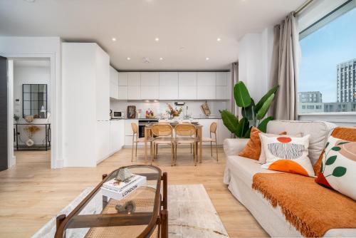 a living room with a couch and a table at Modern Apartment in Wembley Park with Cinema, Gym & Games room in London