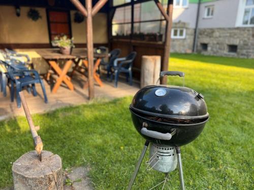 a black grill sitting on a stump in a yard at Vila Šebest in Volary