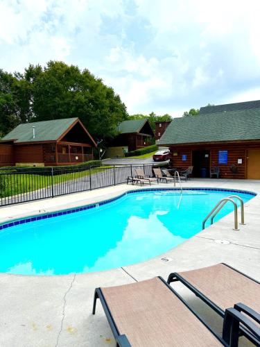 a large swimming pool in front of a log cabin at Escape to the Smokies- Pool, hot tub, cozy cabin, Pigeon Forge in Pigeon Forge