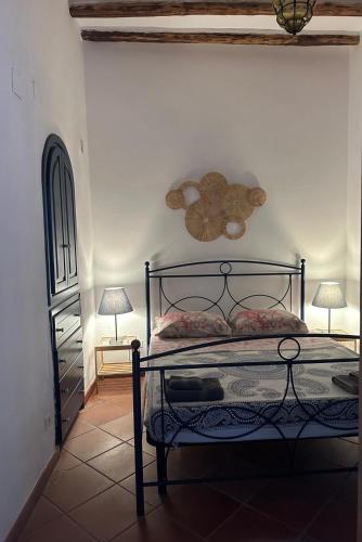 a bedroom with a bed with a fan and two lamps at Schicciolina in Stromboli