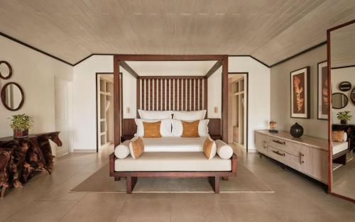 a bedroom with a large bed with a wooden headboard at Carlisle Bay in Old Road