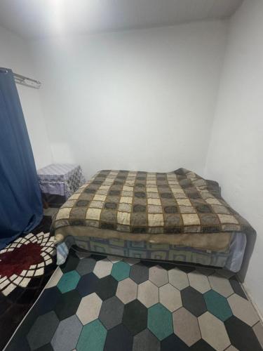 Un dormitorio con una cama y un suelo de cuadros. en Grace House, en Lusaka