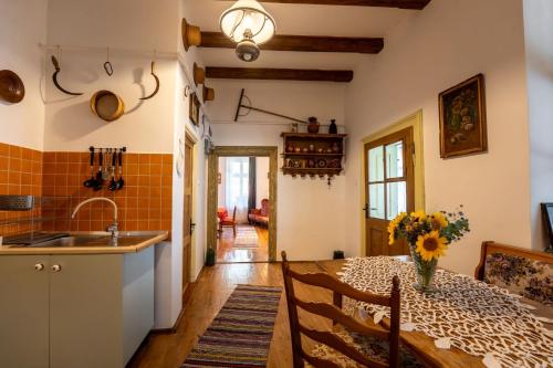 une cuisine avec une table avec un vase de fleurs dans l'établissement Breithofer Cottage Sighisoara, à Sighişoara