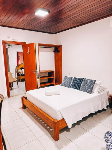 a bedroom with a large bed with a wooden ceiling at Amarilis Pousada Arraial d'Ajuda in Arraial d'Ajuda