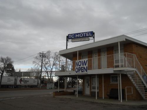 a hotel with a sign that reads now open at TC Motel in Medicine Hat
