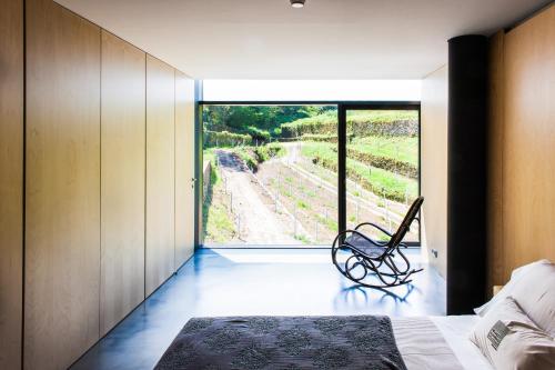 a bedroom with a bed and a window with a view at Melgaço Alvarinho Houses in Melgaço