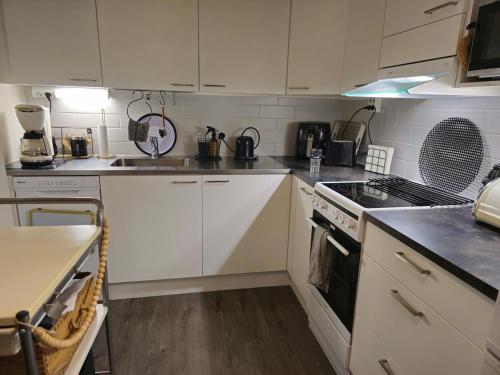 a kitchen with white cabinets and a stove top oven at 3room apartment at central Jyväskylä in Jyväskylä