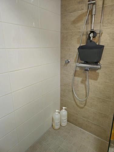 a bathroom with a shower with a basket on the wall at 3room apartment at central Jyväskylä in Jyväskylä
