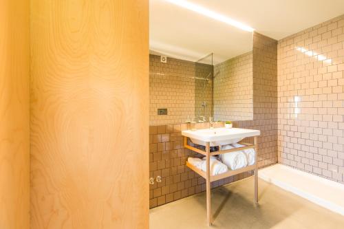 a bathroom with a sink and a bath tub at Melgaço Alvarinho Houses in Melgaço