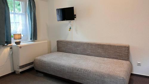 a room with a couch and a tv on the wall at Hostel Ziegenrück in Ziegenrück