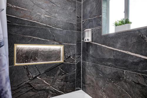 サンアントニオにあるLonghorn- A Birdy Vacation Rentalの黒大理石の壁のバスルーム(鏡付)