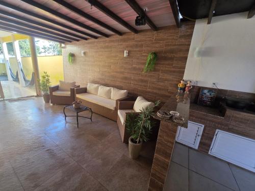a living room with a couch and a brick wall at Casa luxo Maricá in Maricá