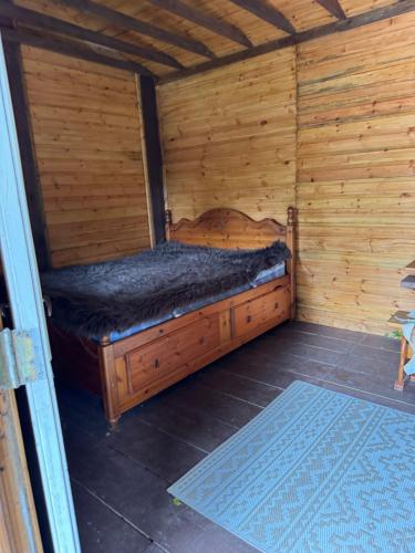 a wooden cabin with a bed in a room at Willow Lodge in Llancarfan