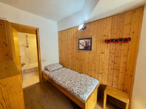 a room with a wooden wall with a bed in it at Sole Alto Charm, Parking & Wi-Fi in Marilleva