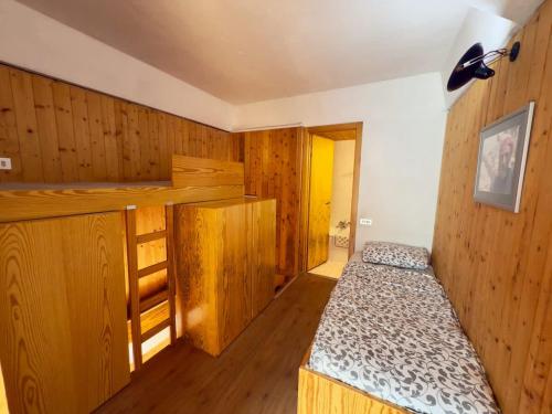 a bedroom with a bed and wooden walls at Sole Alto Charm, Parking & Wi-Fi in Marilleva