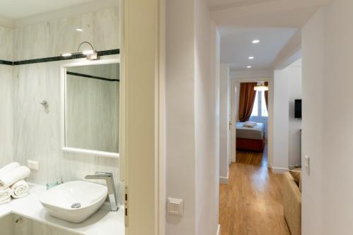 a white bathroom with a toilet and a sink at Athens Plaka Acropolis Suites in Athens