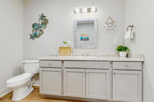 a bathroom with a sink and a toilet and a mirror at Oasis Retreat in Rockport