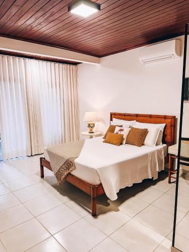 a bedroom with a large bed with a wooden ceiling at Amarilis Pousada Arraial d'Ajuda in Arraial d'Ajuda