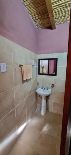 a bathroom with a sink and a tv on the wall at Finca la margarita in Tinogasta