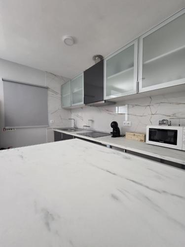 a kitchen with white marble counter tops and cabinets at Douro Valley - Casa do Padrinho in Escamarão