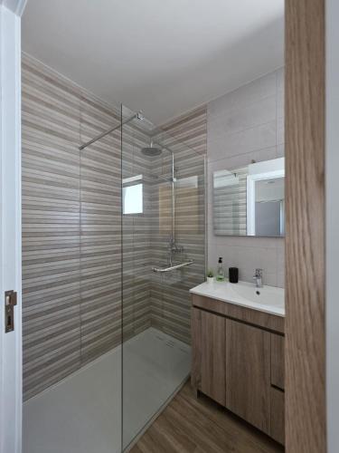 a bathroom with a glass shower and a sink at Douro Valley - Casa do Padrinho in Escamarão