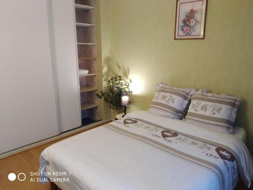 a bedroom with a bed with white sheets and pillows at Chambre Privée 1 BONNEUIL SUR MARNE 30 minutes from Paris in Bonneuil-sur-Marne