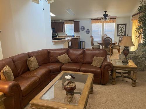een woonkamer met een bruine leren bank en een tafel bij Parker Pair - Sunset Escape in Parker