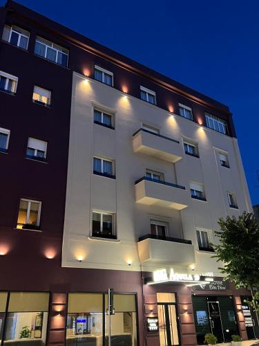 a large white building with lights on it at Hotel Aquila D in Durrës
