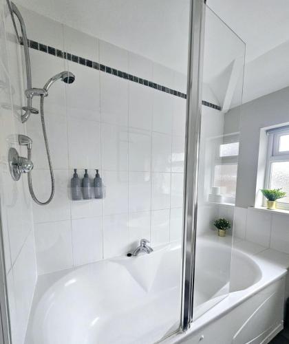 a white bathroom with a tub and a shower at Saxe House in Sheldon