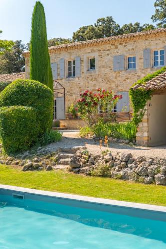 a house with a pool in front of a building at Mas Bella Cortis in La Garde-Adhémar