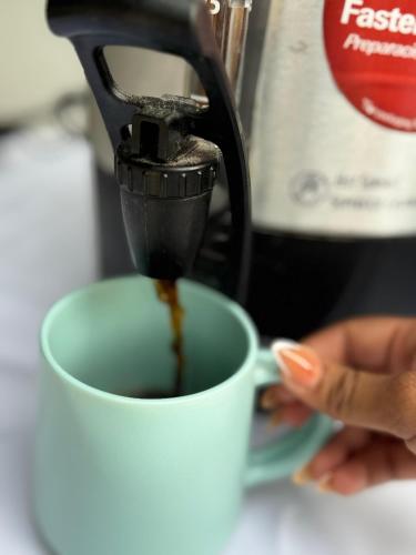 a person is pouring coffee into a cup at Hotel Naturaleza Bacalar- Gratis bicibletas in Bacalar