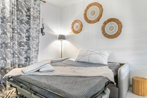 a bedroom with a bed with a lamp and plates on the wall at Charmant duplex moderne proche plage Anse Marcel in Anse Marcel 