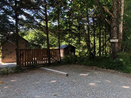 a house with a fence and a wooden gate at The Dogwood Cabin - Cowichan Valley Bunkie Glamping in Duncan