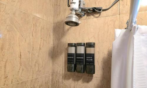 ein Badezimmer mit einer Lampe und drei Flaschen an der Wand in der Unterkunft Oscar Building - Apto#1 in San Juan