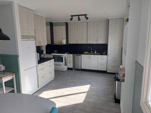 a kitchen with white cabinets and white appliances at fijn huis in Hagfors in Hagfors