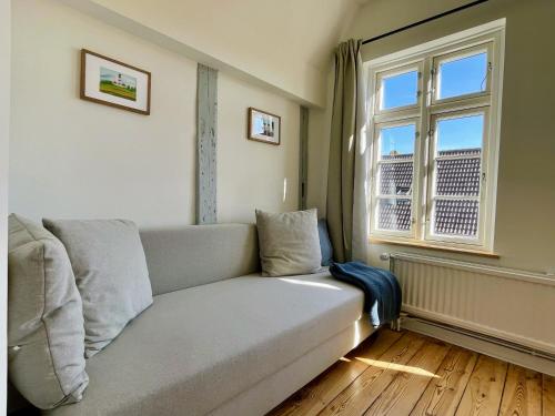 a living room with a couch and a window at Alte Polizei in Friedrichstadt